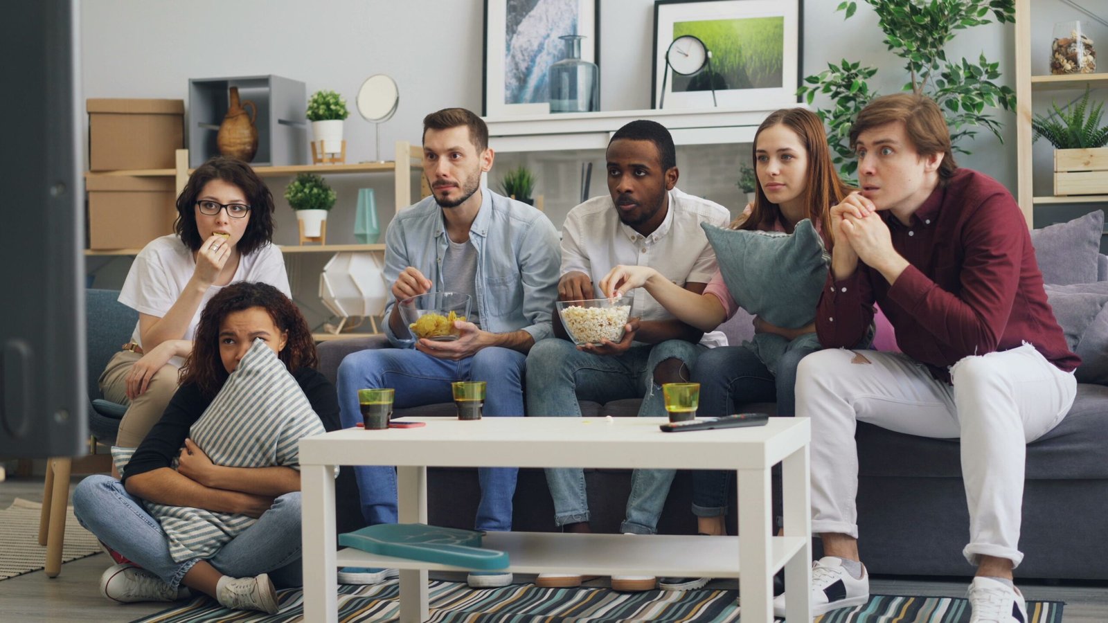 A group of friends sit together on a couch watching a movie at home, the way most viewers will stream Kevin Hart’s 72 Hours on Netflix (Photo: Pexels)