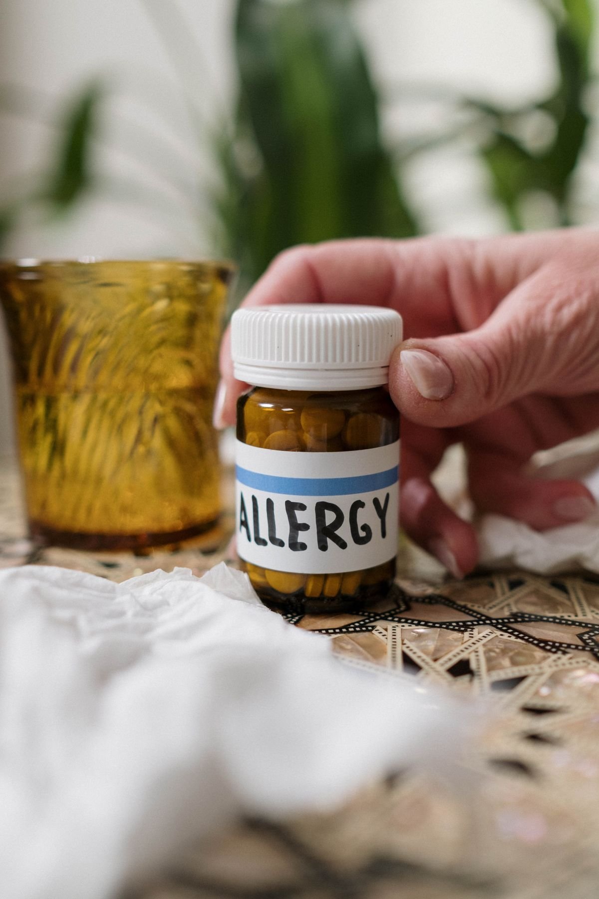 Close-up of an allergy medication bottle with tissues