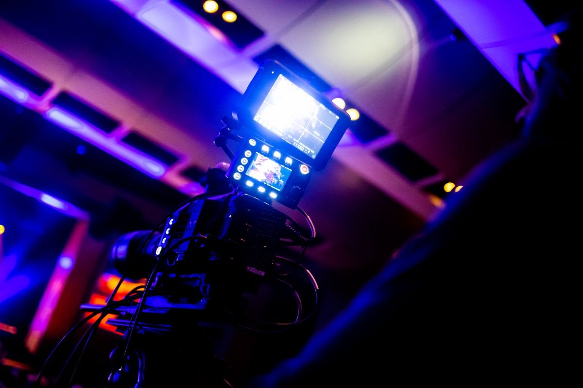 A broadcast camera under studio lights