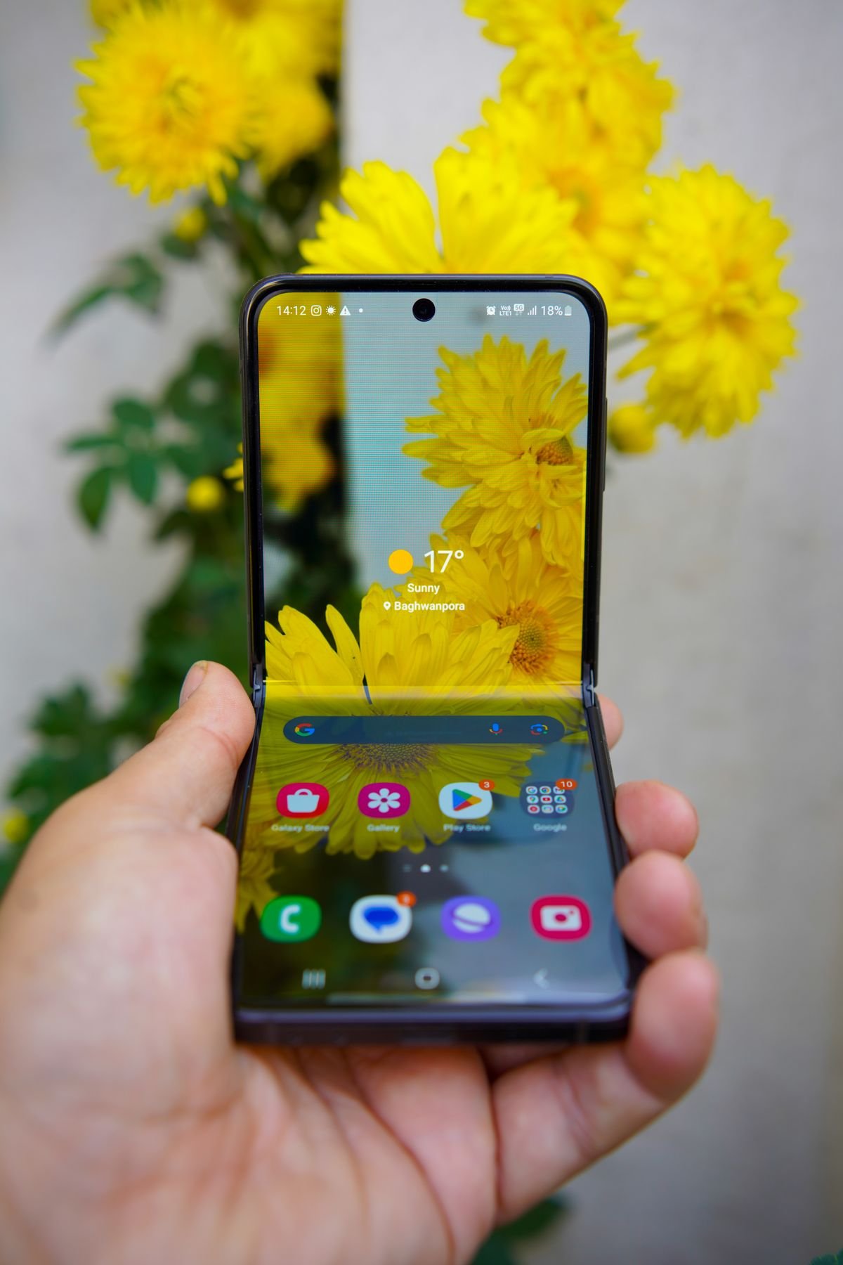 A hand holding an open foldable smartphone