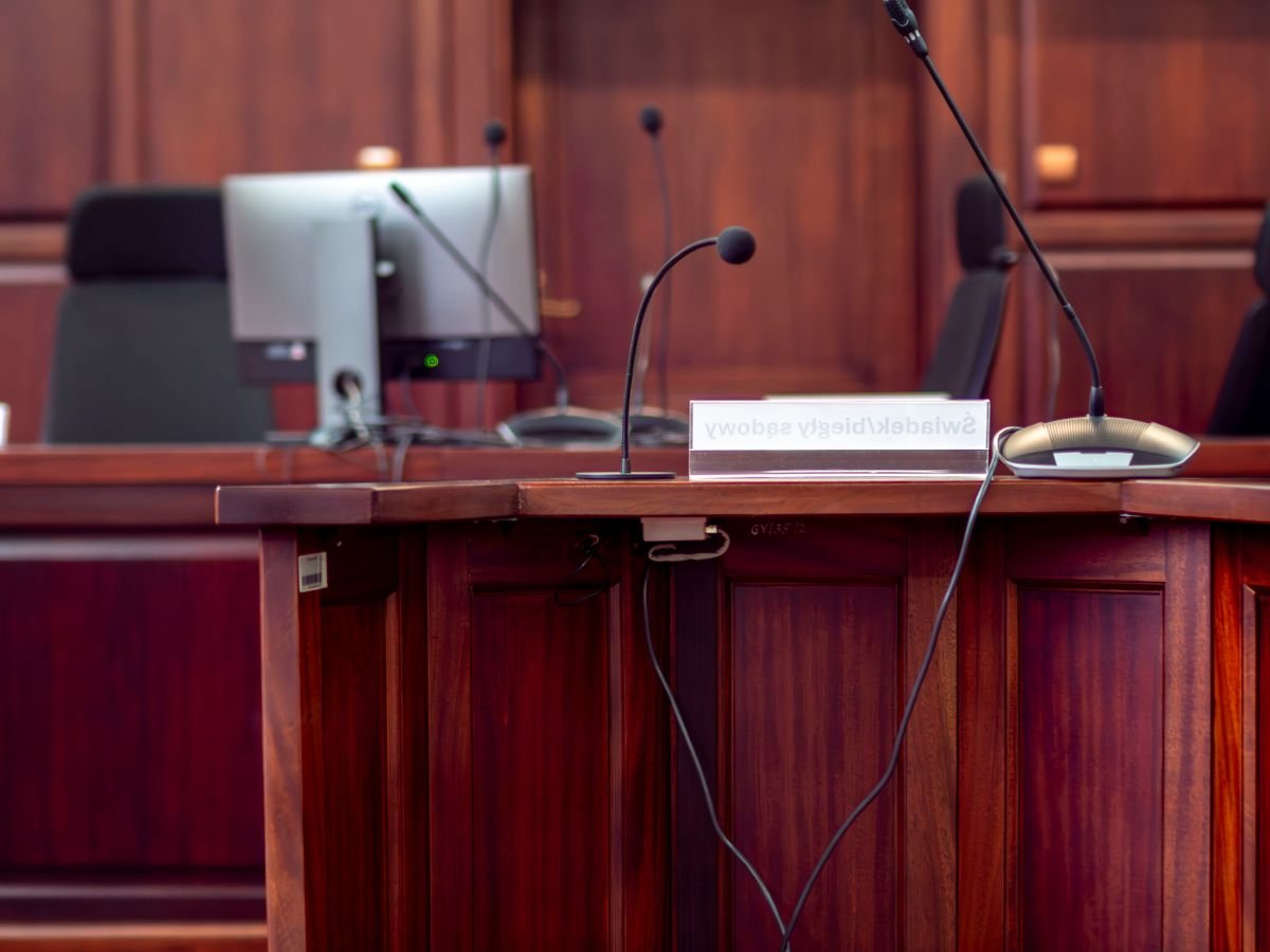 A podium fitted with microphones in a hearing-room setting.