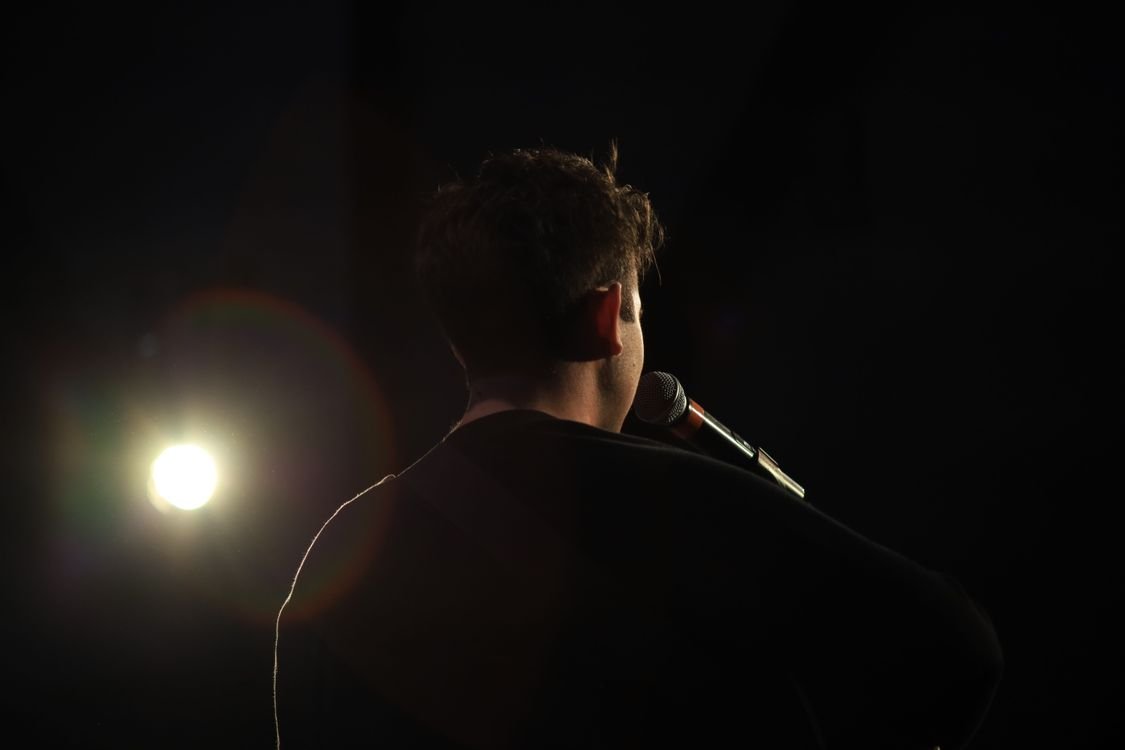 Singer performing under stage spotlight