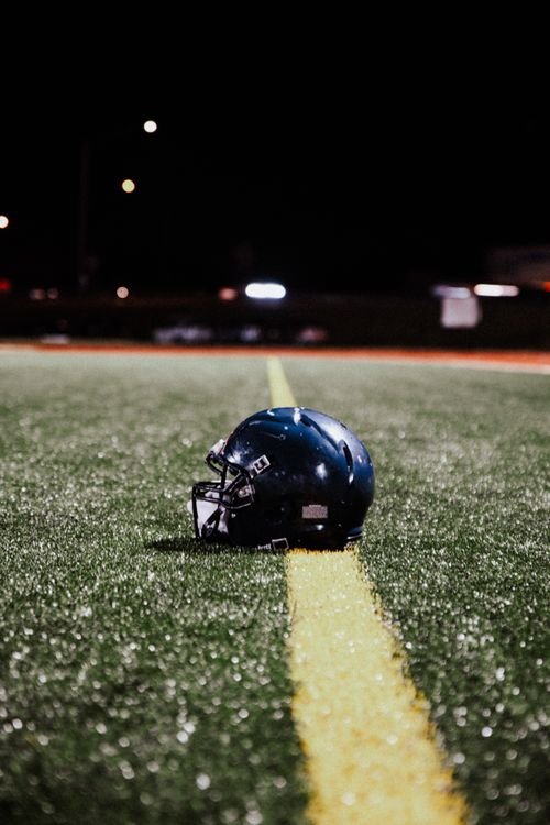 Football helmet resting on the field at night