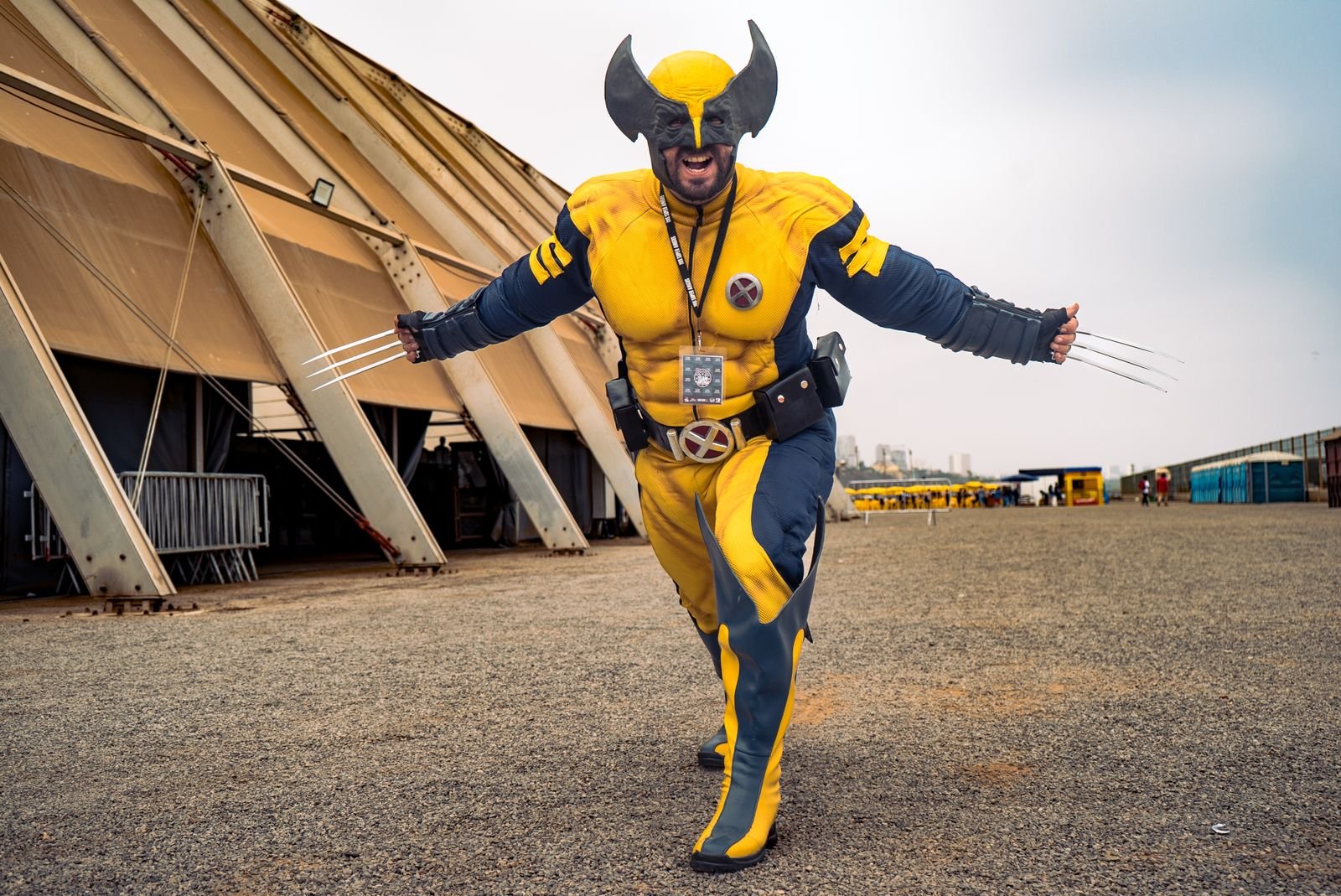 A superhero cosplayer poses outdoors at a fan convention, reflecting Marvel fandom culture