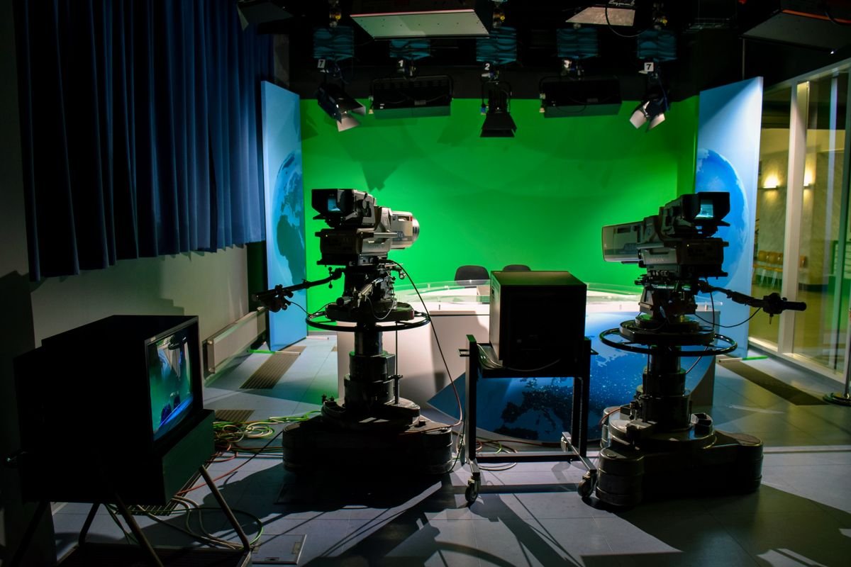 A television studio with broadcast cameras and green screen