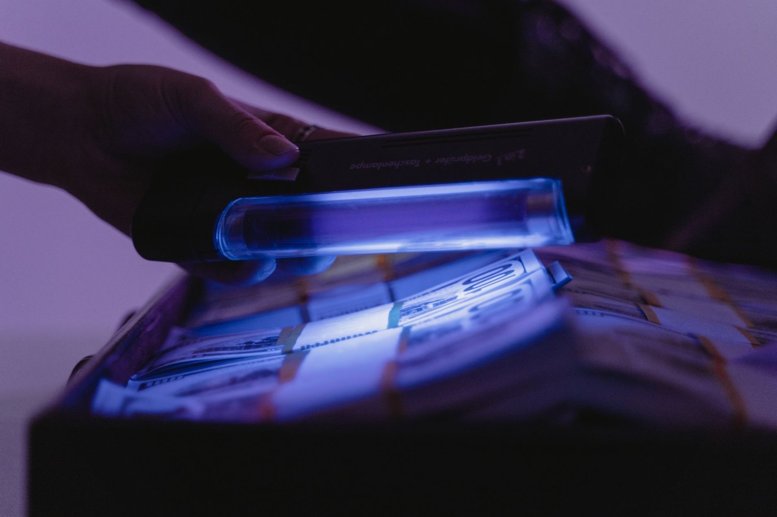 Close-up of counterfeit euro banknotes being inspected under ultraviolet light.