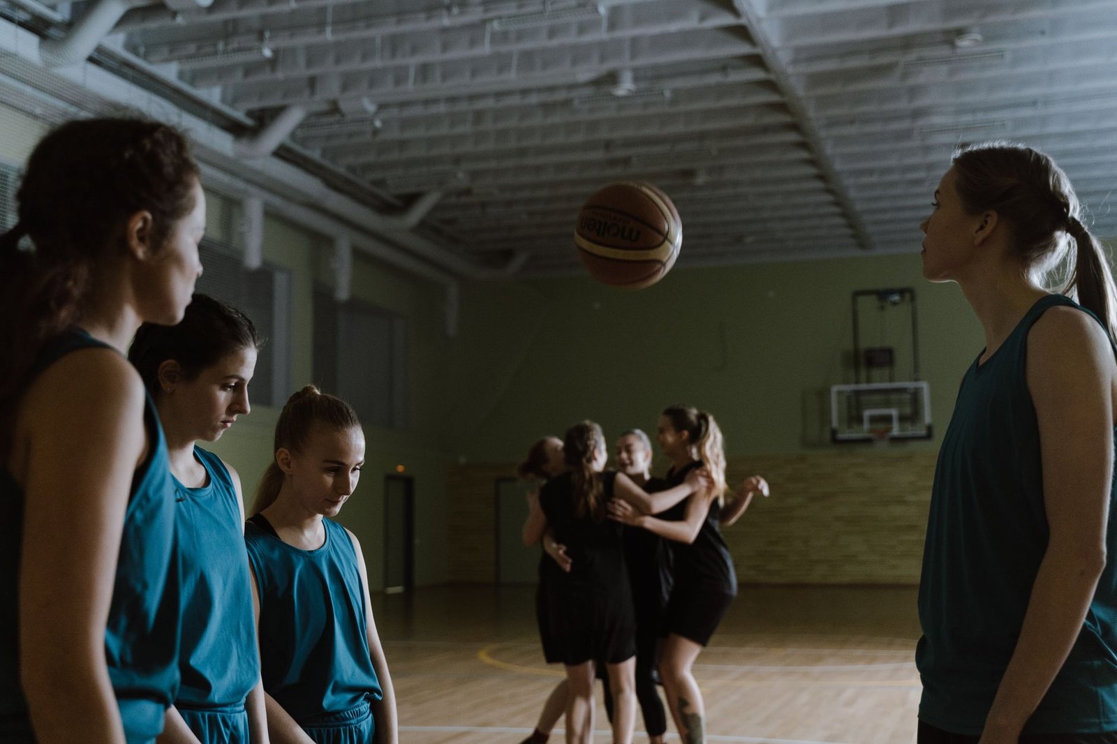 Women basketball players in a team huddle, symbolizing solidarity and collective voice in professional sports.