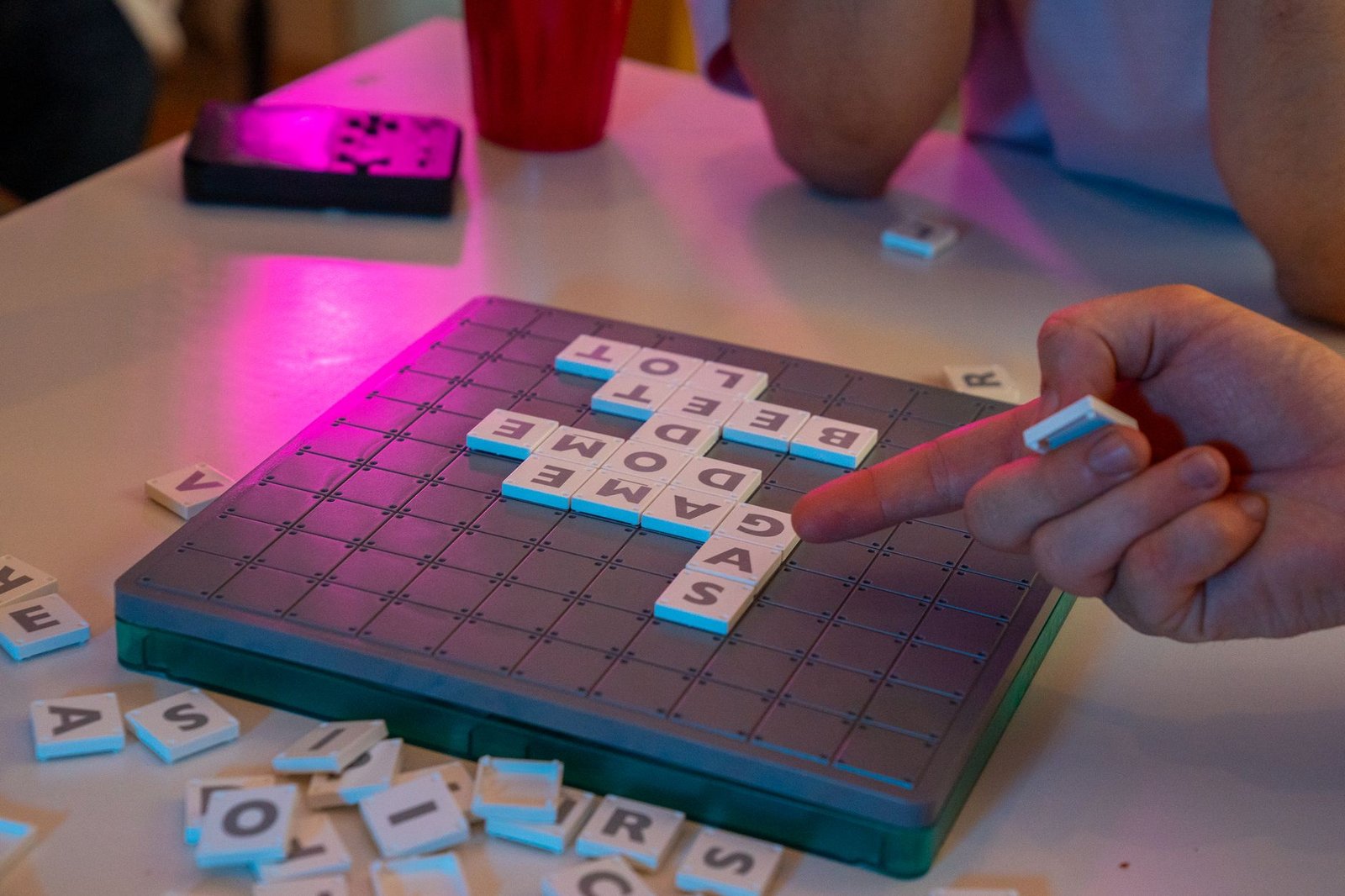 Someone playing a mobile word game, similar to the NYT Strands puzzle experience on a smartphone