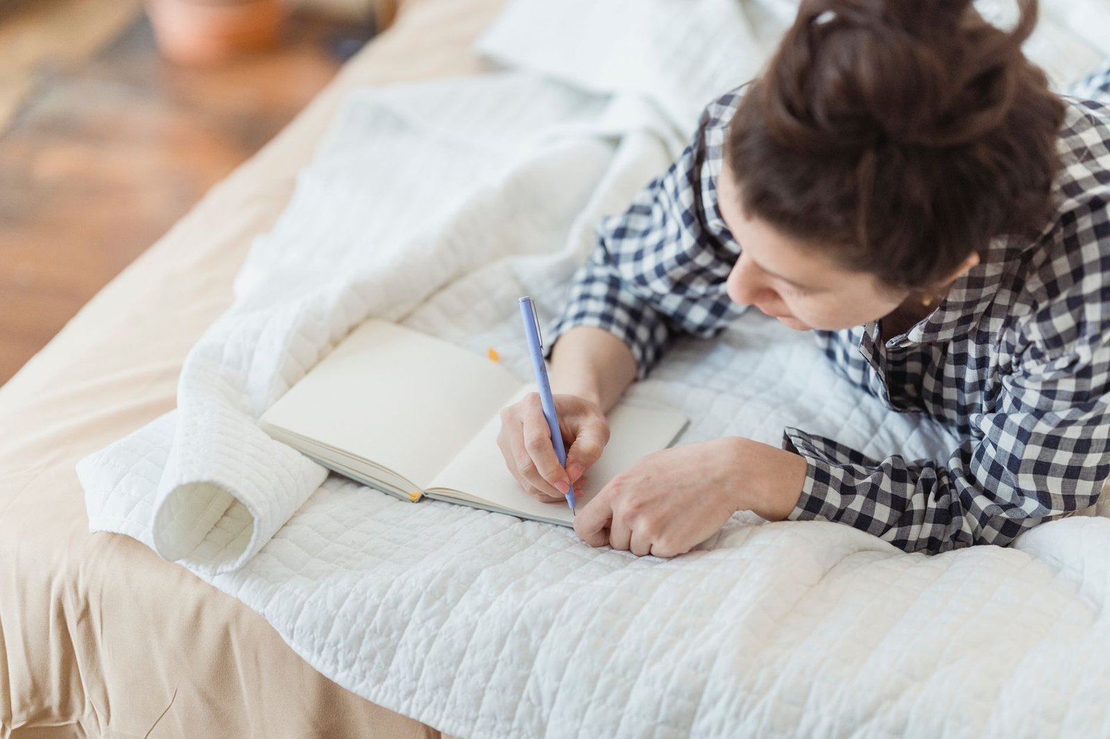 A woman writing in a journal, reflecting a personal new chapter announcement like Rumer Willis's